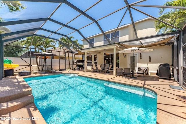 view of pool featuring a patio, ceiling fan, fence, and a lanai