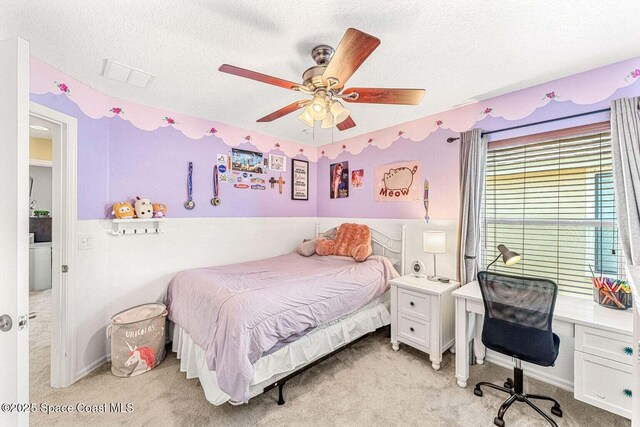 bedroom with light colored carpet, a textured ceiling, a desk, and ceiling fan