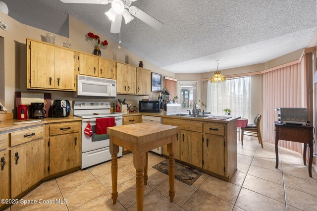 225 Chalet Ave, Indialantic, FL 32903 - kitchen featuring white appliances, a textured ceiling, a peninsula, vaulted ceiling, and light countertops