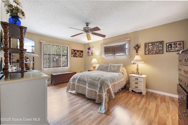 225 Chalet Ave, Indialantic, FL 32903 - bedroom featuring light wood-style floors, baseboards, a textured ceiling, and a ceiling fan