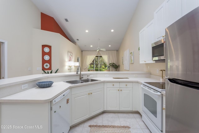 kitchen with appliances with stainless steel finishes, a sink, light tile patterned floors, light countertops, and white cabinetry