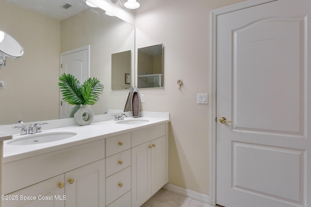 bathroom with double vanity, tile patterned flooring, and baseboards