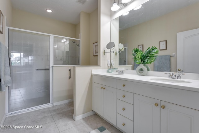 bathroom with tile patterned floors, a stall shower, double vanity, baseboards, and recessed lighting