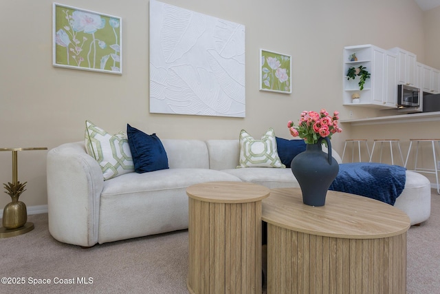 carpeted living area featuring baseboards