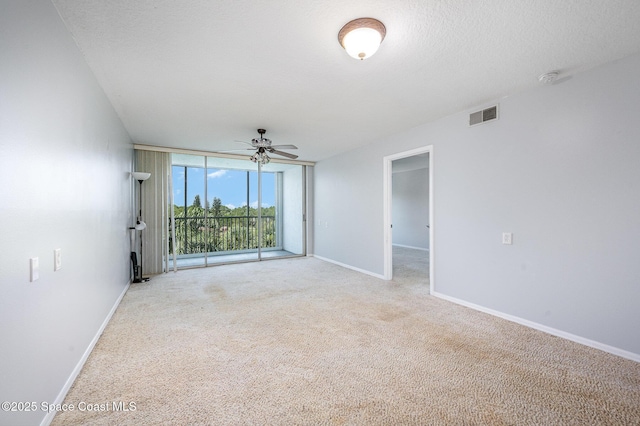 1420 Huntington Ln Unit 2402, Rockledge, FL 32955 - empty room with light colored carpet, baseboards, ceiling fan, a wall of windows, and a smoke detector