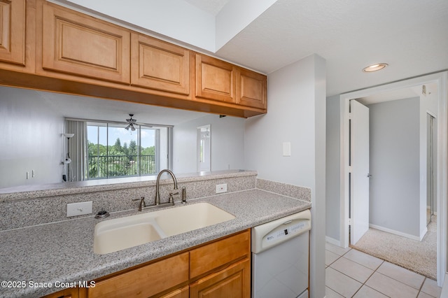 1420 Huntington Ln Unit 2402, Rockledge, FL 32955 - kitchen featuring dishwasher, a sink, light tile patterned flooring, brown cabinetry, and baseboards