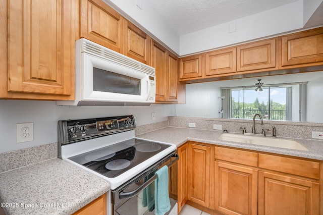 1420 Huntington Ln Unit 2402, Rockledge, FL 32955 - kitchen with white microwave, range with electric cooktop, a sink, light countertops, and brown cabinetry