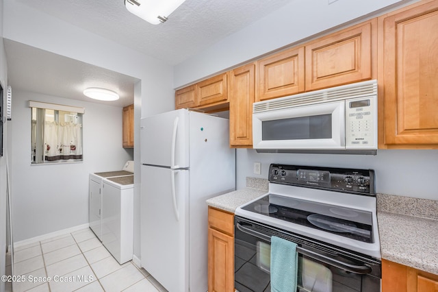1420 Huntington Ln Unit 2402, Rockledge, FL 32955 - kitchen with white appliances, washing machine and clothes dryer, light tile patterned flooring, baseboards, and a textured ceiling