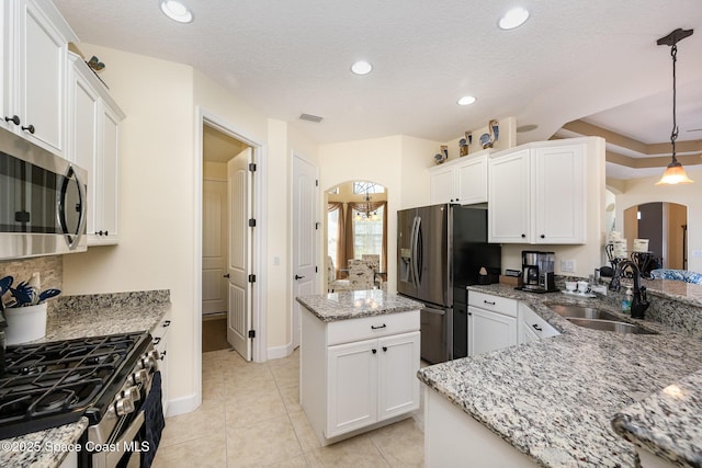 679 Sheridan Woods Dr, Melbourne, FL 32904 - kitchen with stainless steel appliances, a sink, arched walkways, white cabinets, and light stone countertops