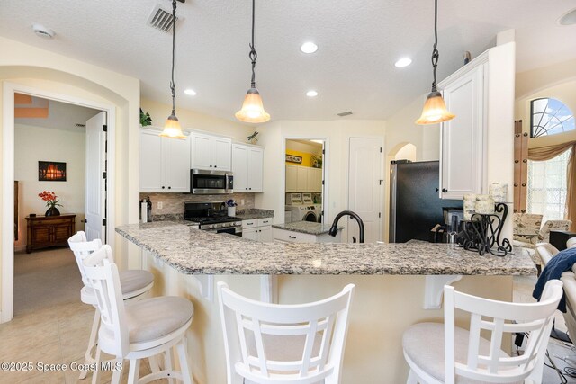 679 Sheridan Woods Dr, Melbourne, FL 32904 - kitchen featuring appliances with stainless steel finishes, a peninsula, backsplash, white cabinetry, and recessed lighting