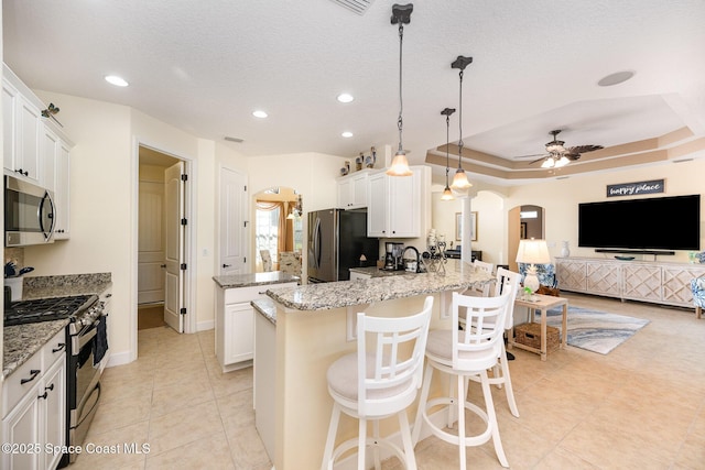 679 Sheridan Woods Dr, Melbourne, FL 32904 - kitchen with stainless steel appliances, arched walkways, ceiling fan, a peninsula, and light tile patterned floors