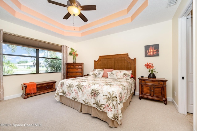 679 Sheridan Woods Dr, Melbourne, FL 32904 - bedroom featuring light colored carpet, a raised ceiling, baseboards, and a ceiling fan