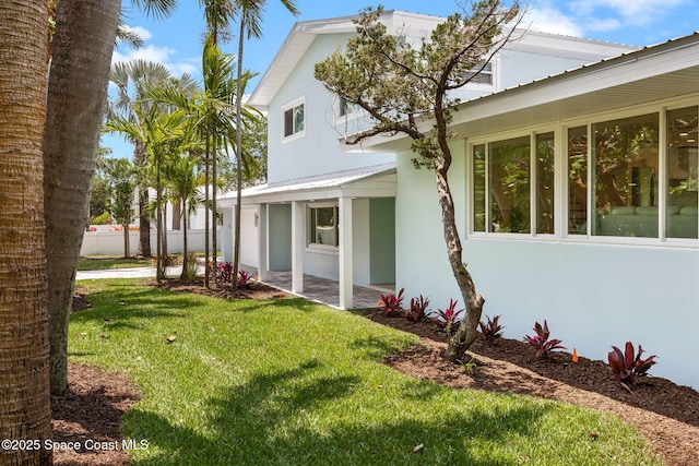 view of home's exterior featuring stucco siding, a patio, and metal roof