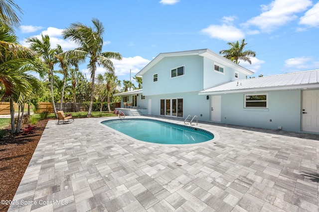 view of swimming pool featuring fence and a patio area
