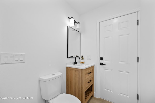 half bath featuring vanity and toilet