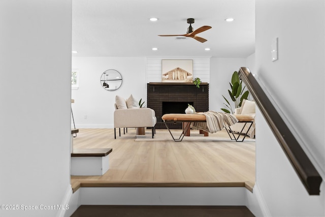 living area with ceiling fan, recessed lighting, wood finished floors, a fireplace, and baseboards