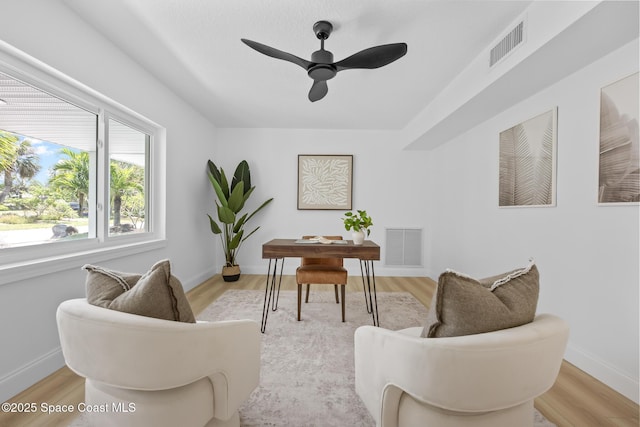 office area featuring baseboards, light wood finished floors, and ceiling fan