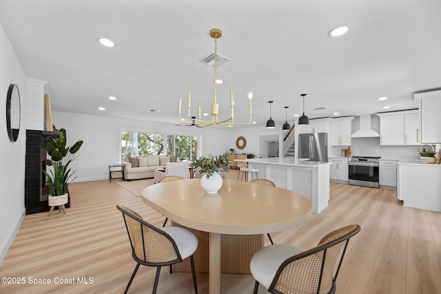 dining space featuring light wood-type flooring, recessed lighting, stairway, baseboards, and a chandelier