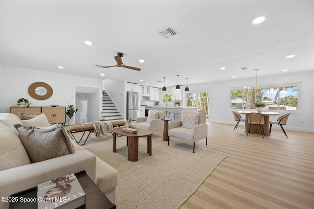 living area with recessed lighting, stairs, light wood-type flooring, baseboards, and ceiling fan