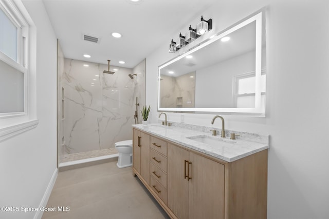 full bath featuring recessed lighting, double vanity, toilet, a marble finish shower, and baseboards