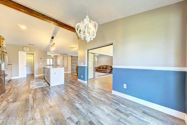 kitchen with a chandelier, light wood finished floors, open floor plan, decorative light fixtures, and light countertops