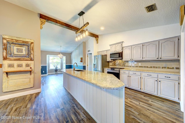 kitchen featuring appliances with stainless steel finishes, a sink, dark wood-type flooring, baseboards, and a center island with sink