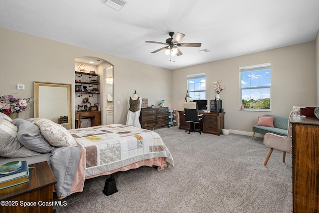 3631 Stabane Pl, Melbourne, FL 32940 - carpeted bedroom featuring a desk, baseboards, ceiling fan, arched walkways, and connected bathroom