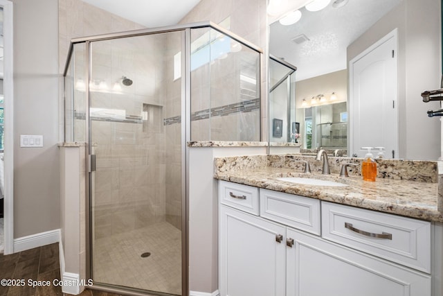 3631 Stabane Pl, Melbourne, FL 32940 - full bathroom with vanity, a shower stall, baseboards, and wood finished floors