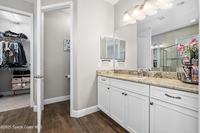 3631 Stabane Pl, Melbourne, FL 32940 - full bath featuring wood tiled floors, vanity, a walk in closet, a stall shower, and baseboards