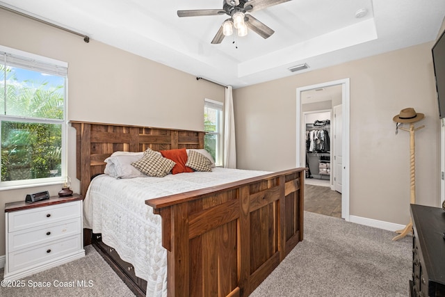 3631 Stabane Pl, Melbourne, FL 32940 - bedroom with light carpet, a raised ceiling, ceiling fan, a walk in closet, and baseboards