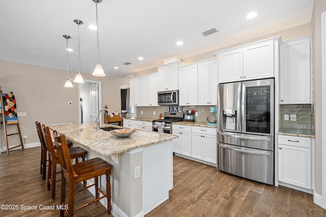 3631 Stabane Pl, Melbourne, FL 32940 - kitchen featuring stainless steel appliances, a sink, a center island with sink, dark wood-style floors, and recessed lighting