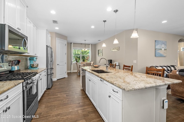 3631 Stabane Pl, Melbourne, FL 32940 - kitchen featuring stainless steel appliances, a sink, white cabinets, backsplash, and an island with sink