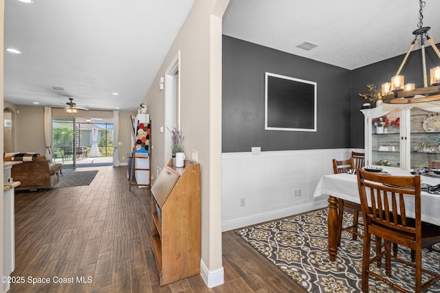 3631 Stabane Pl, Melbourne, FL 32940 - dining space featuring wood finished floors, a wainscoted wall, ceiling fan, arched walkways, and a chandelier