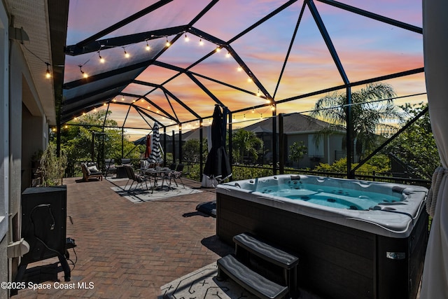 3631 Stabane Pl, Melbourne, FL 32940 - pool at dusk featuring a hot tub, a patio area, a lanai, and outdoor dining area