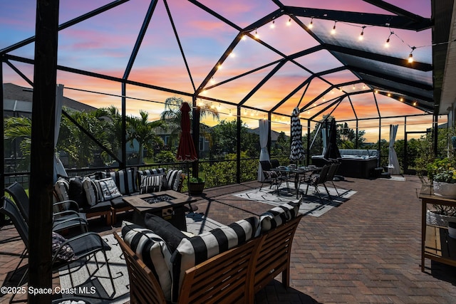 3631 Stabane Pl, Melbourne, FL 32940 - patio terrace at dusk featuring a hot tub, an outdoor living space with a fire pit, a patio area, and glass enclosure
