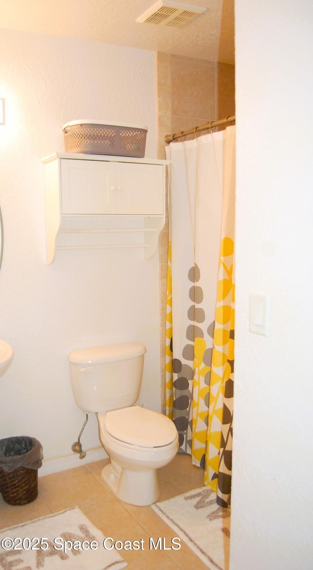 bathroom featuring tile patterned floors, a shower with curtain, and toilet