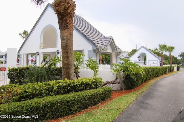 view of property exterior with stucco siding and a tiled roof