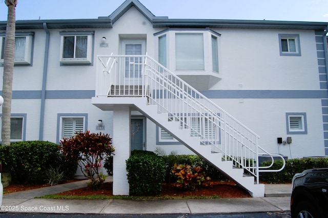 view of front of home featuring stairs and stucco siding