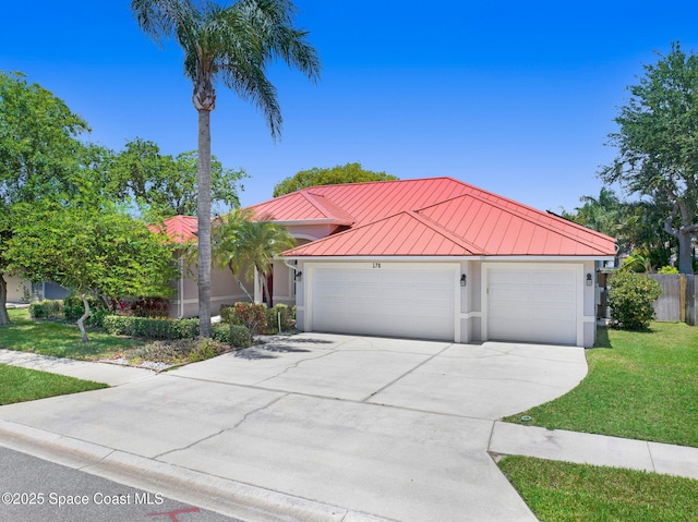 178 Cove Loop Dr, Merritt Island, FL 32953 - view of front facade featuring a standing seam roof, driveway, metal roof, stucco siding, and a garage