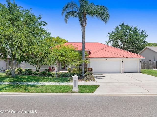 178 Cove Loop Dr, Merritt Island, FL 32953 - view of front of house with a standing seam roof, a garage, concrete driveway, and metal roof