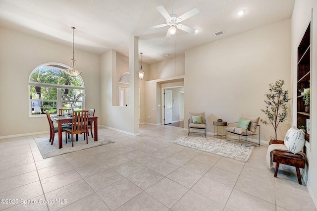 178 Cove Loop Dr, Merritt Island, FL 32953 - dining room featuring a ceiling fan, light tile patterned flooring, baseboards, and a towering ceiling