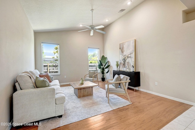 178 Cove Loop Dr, Merritt Island, FL 32953 - living area featuring vaulted ceiling, ceiling fan, light wood finished floors, baseboards, and a textured ceiling