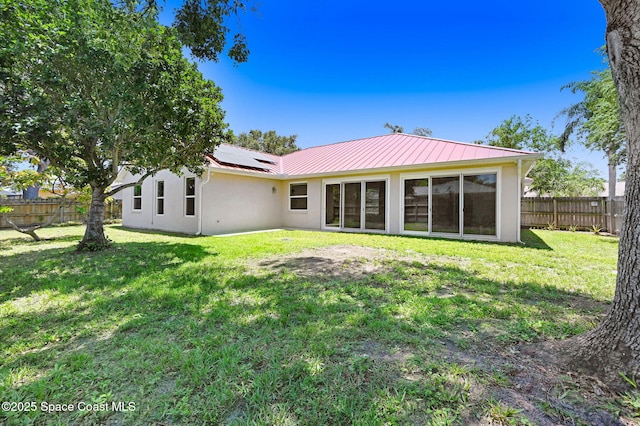 178 Cove Loop Dr, Merritt Island, FL 32953 - rear view of house with stucco siding, roof mounted solar panels, and metal roof