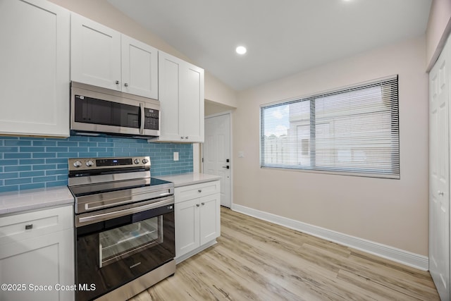 1411 Club Gardens Dr NE, Palm Bay, FL 32905 - kitchen featuring stainless steel appliances, baseboards, light countertops, tasteful backsplash, and light wood finished floors
