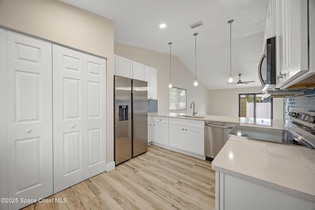 1411 Club Gardens Dr NE, Palm Bay, FL 32905 - kitchen with stainless steel appliances, a ceiling fan, vaulted ceiling, light stone counters, and a sink