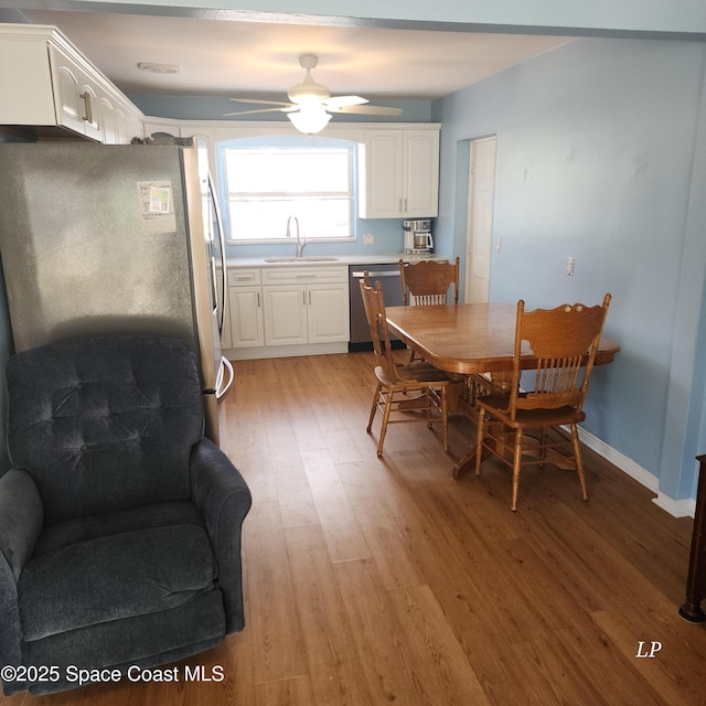 dining room with light wood-style flooring, ceiling fan, and baseboards