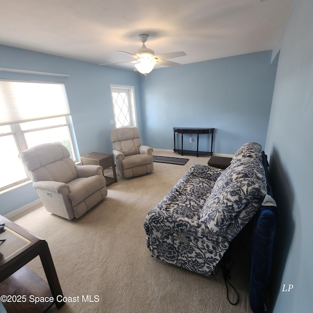 living room with carpet floors, a ceiling fan, and baseboards