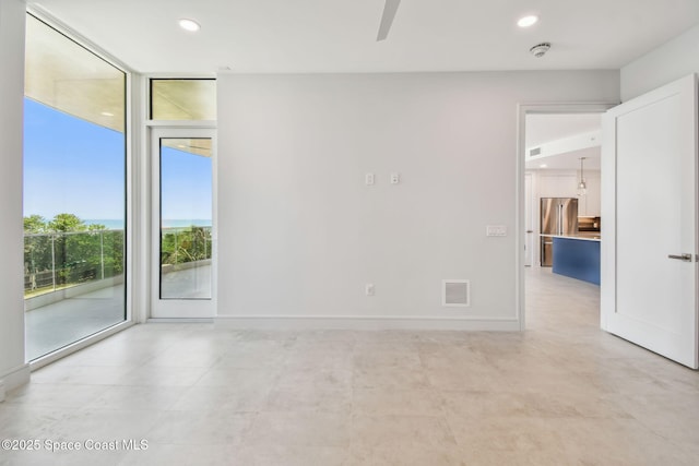 unfurnished room with a ceiling fan, recessed lighting, expansive windows, baseboards, and a smoke detector