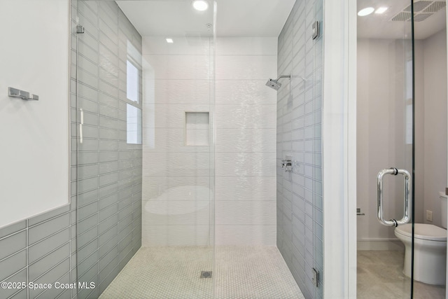 full bath featuring a stall shower, toilet, and tile patterned floors