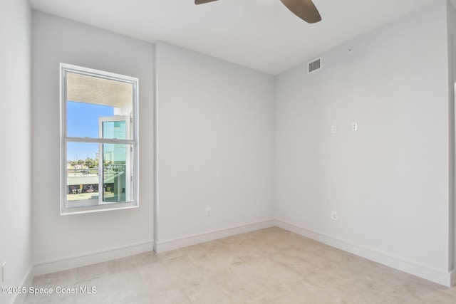 spare room featuring ceiling fan and baseboards